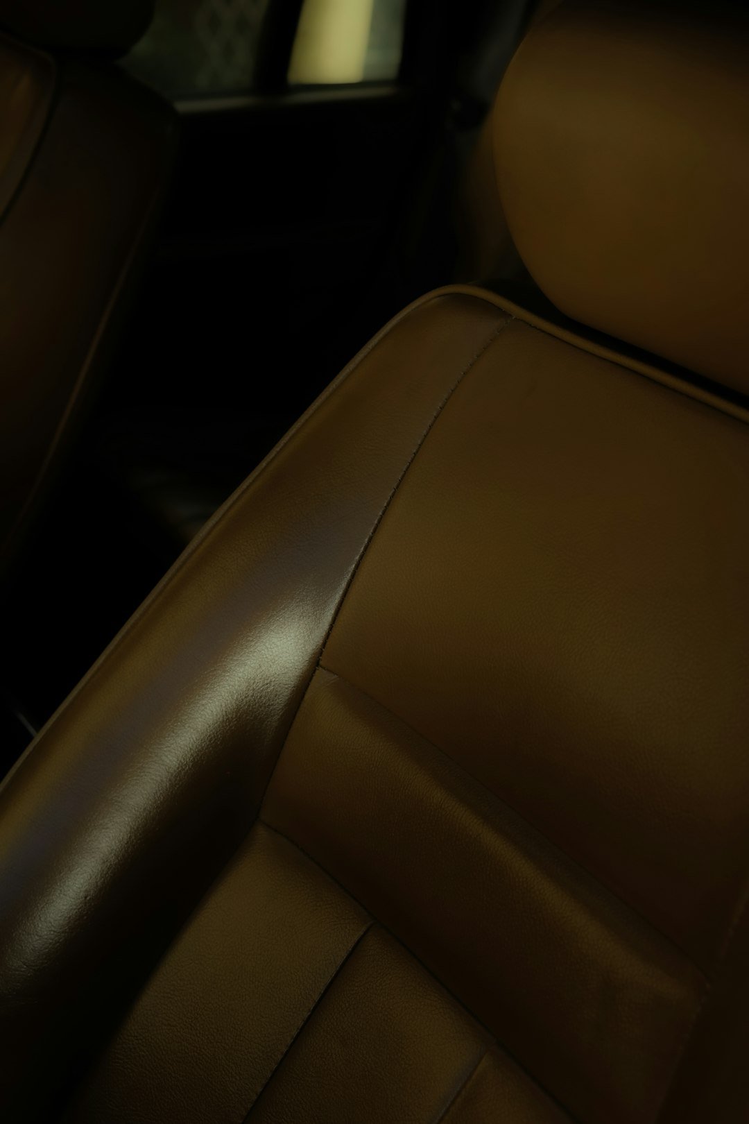 Close-up of a brown leather car seat.