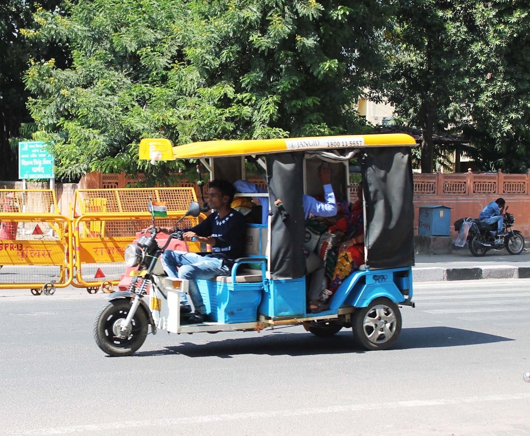 a man driving a three wheeled vehicle down a street
