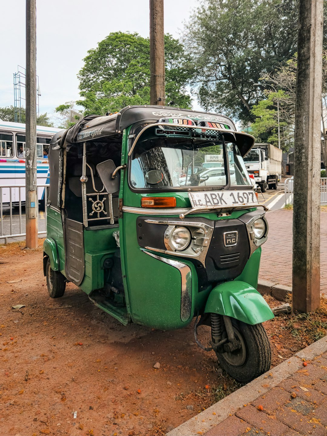 A green three wheeled vehicle parked on the side of the road