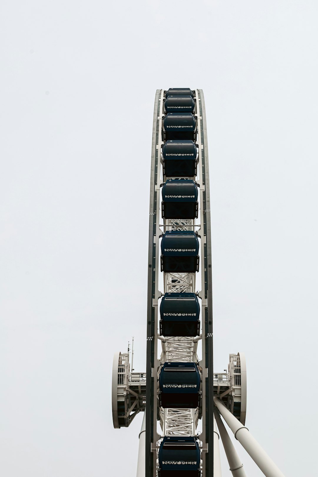 A ferris wheel rises against a cloudy sky.