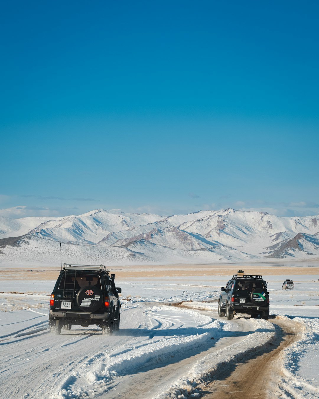 Cars drive through the snowy mountains.