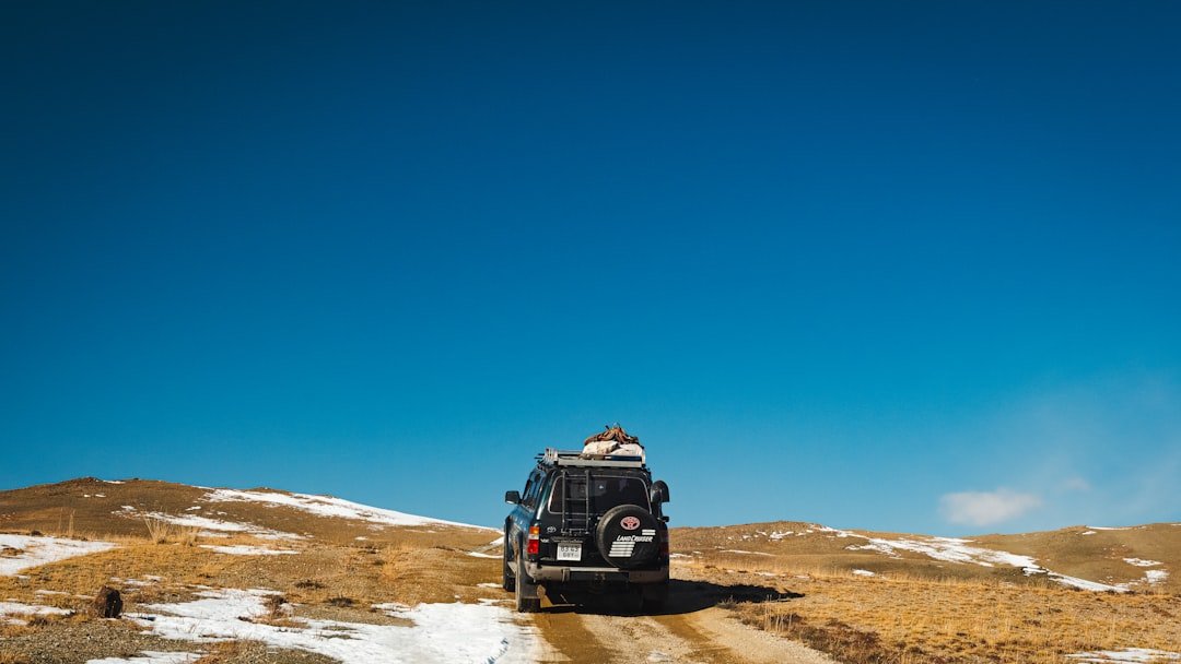 A rugged vehicle traverses a beautiful mountain trail.