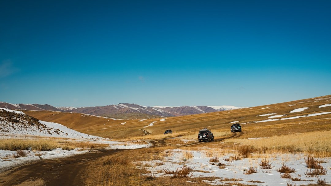 Cars drive on a road through the mountains.