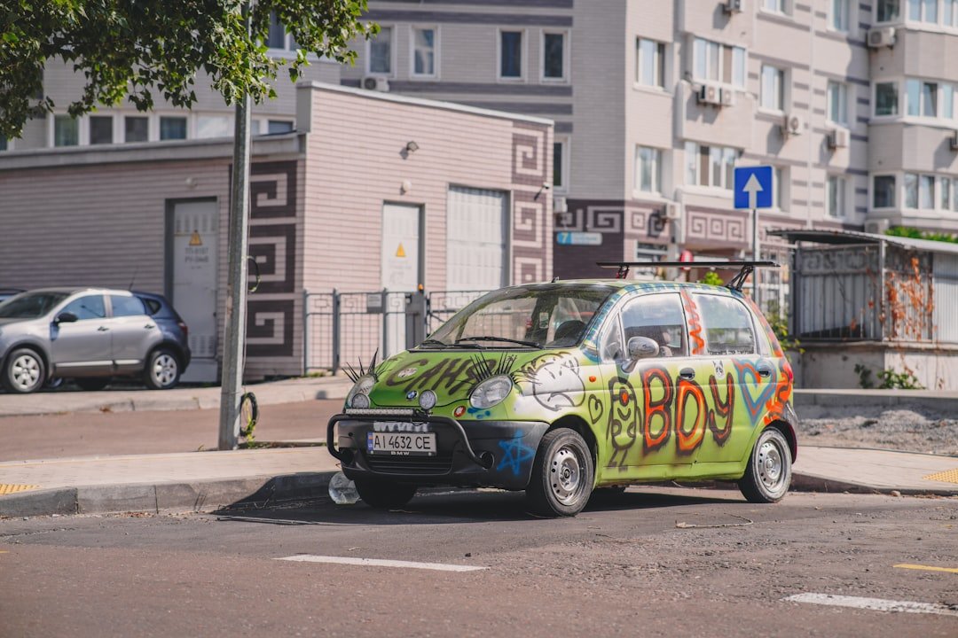 A small green car parked on the side of the road