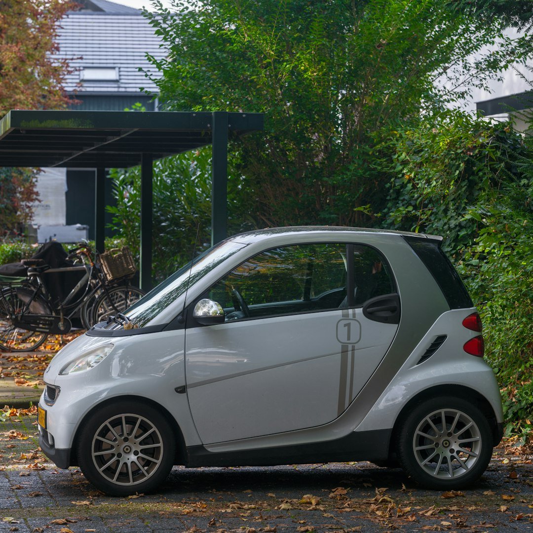 A smart car parked in front of a house