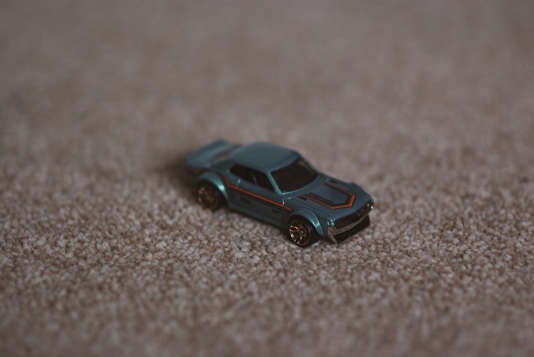 a toy car sitting on a carpeted floor