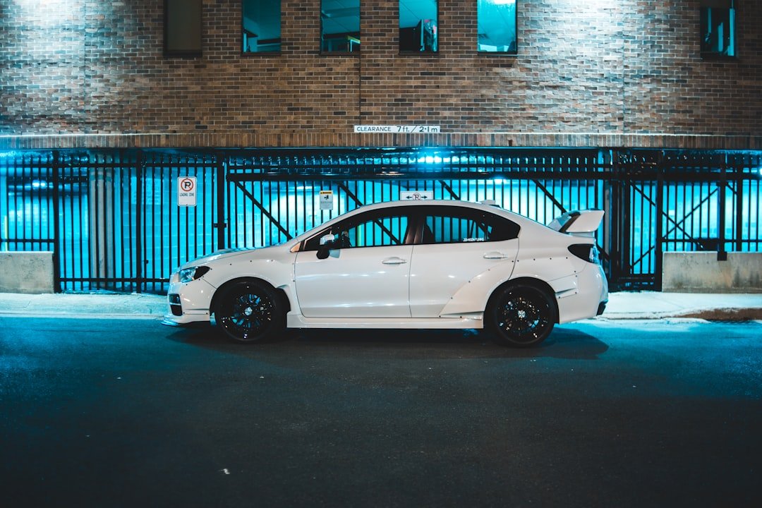 white coupe parked beside building during daytime