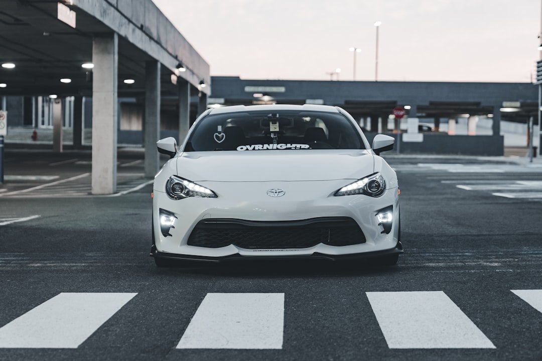 A white car is parked in a parking lot