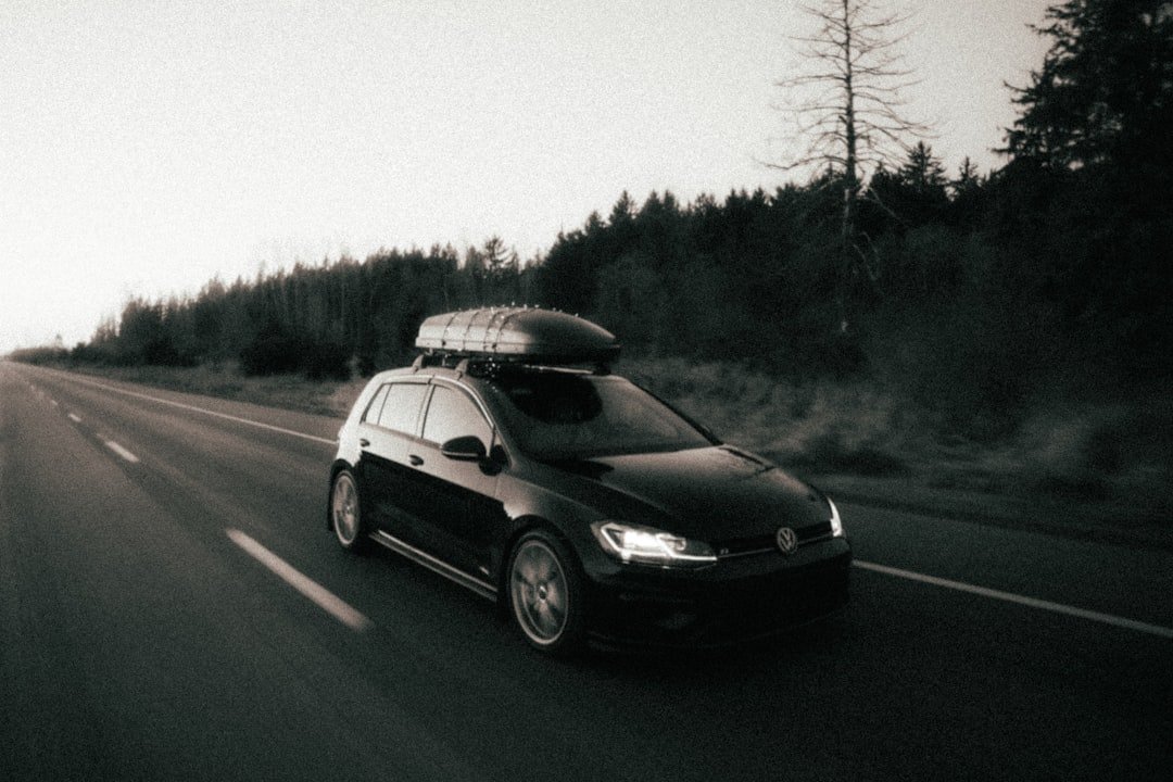 a car driving down a road with a surfboard on top of it