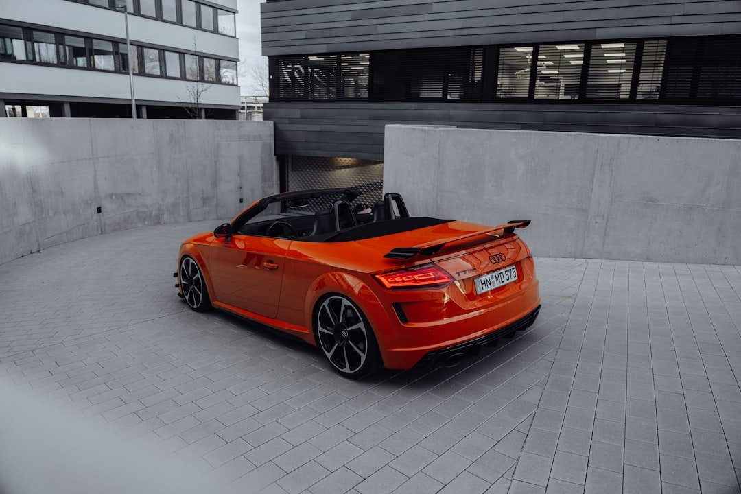 an orange sports car parked in front of a building
