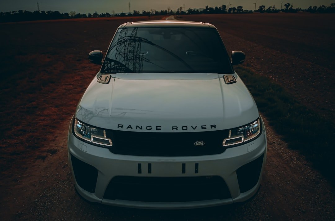 A white range rover parked on a dirt road