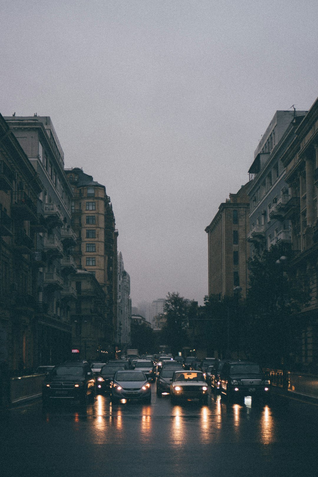 cars on road between buildings during daytime