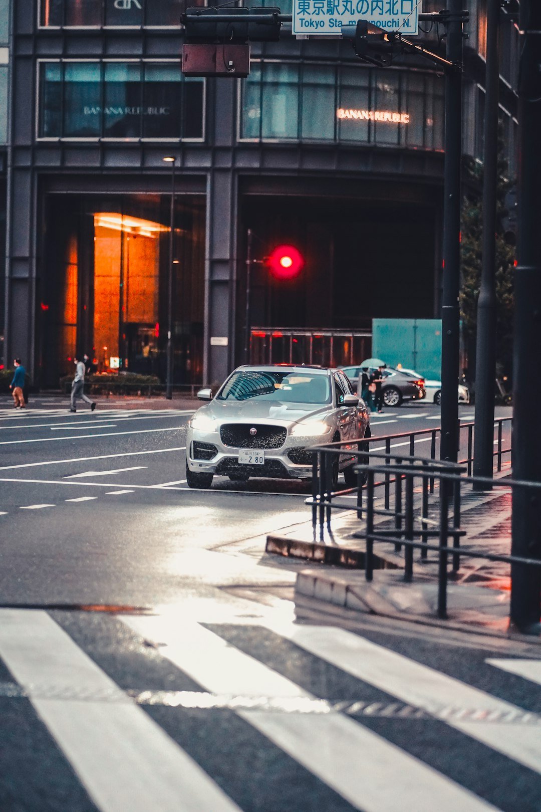 a car driving down a street next to a tall building