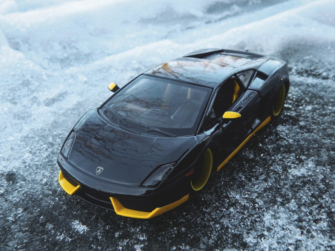 a black and yellow toy car on ice
