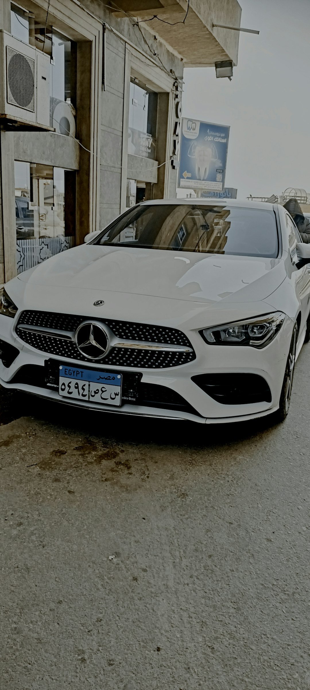a white car parked in front of a building