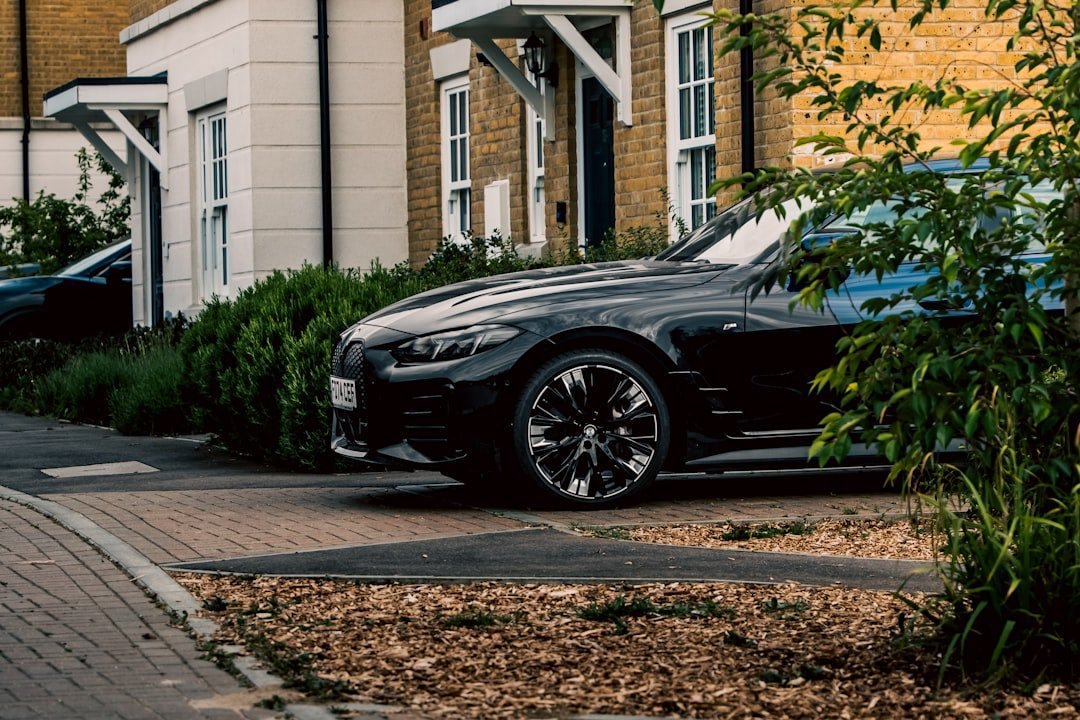 A black car is parked in front of a house.