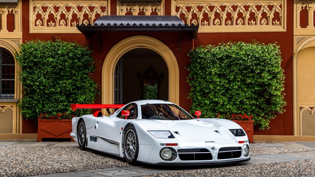 A white sports car parked in front of a building
