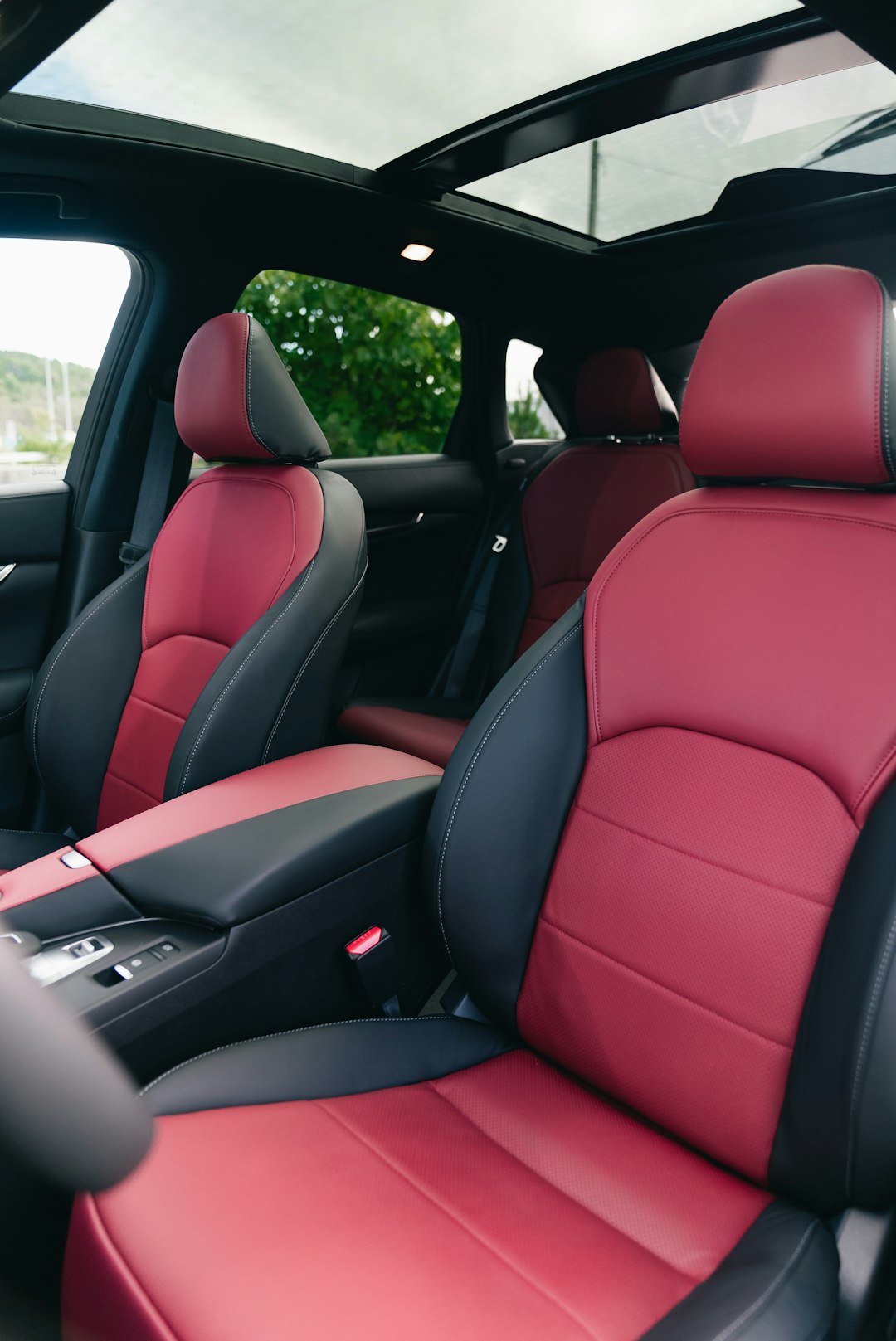 Red and black leather car interior with sunroof.