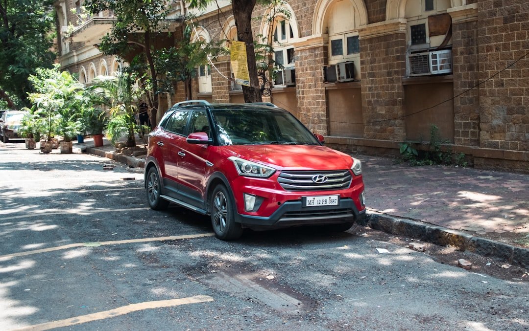 A red suv is parked on a street.