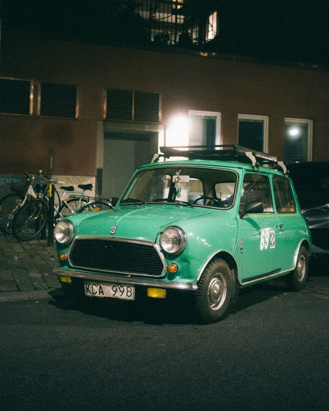 Green vintage mini cooper parked at night