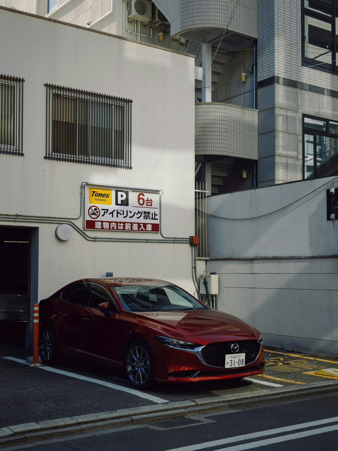 Red car parked in a white building entrance.