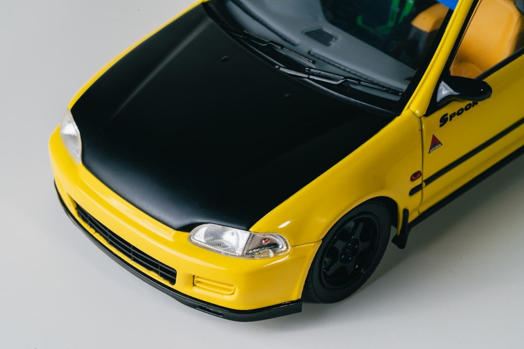 Yellow car with a black hood and black wheels