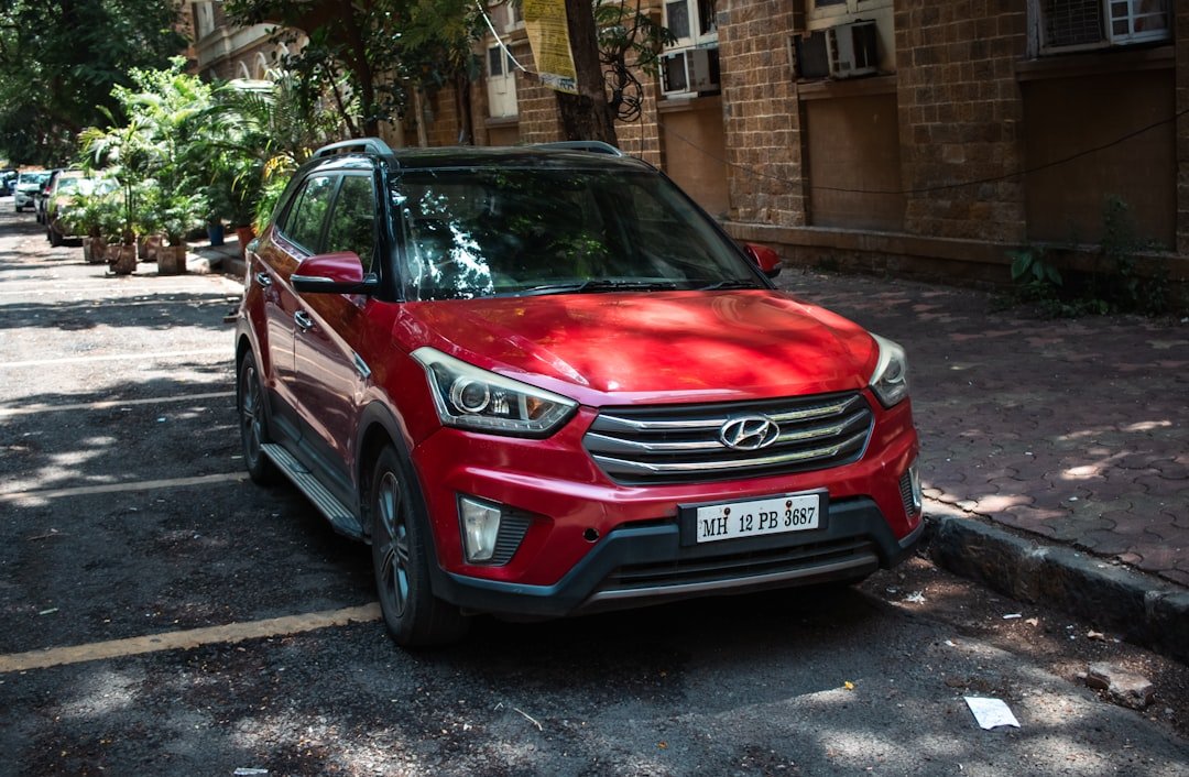 A red hyundai creta is parked on a street.