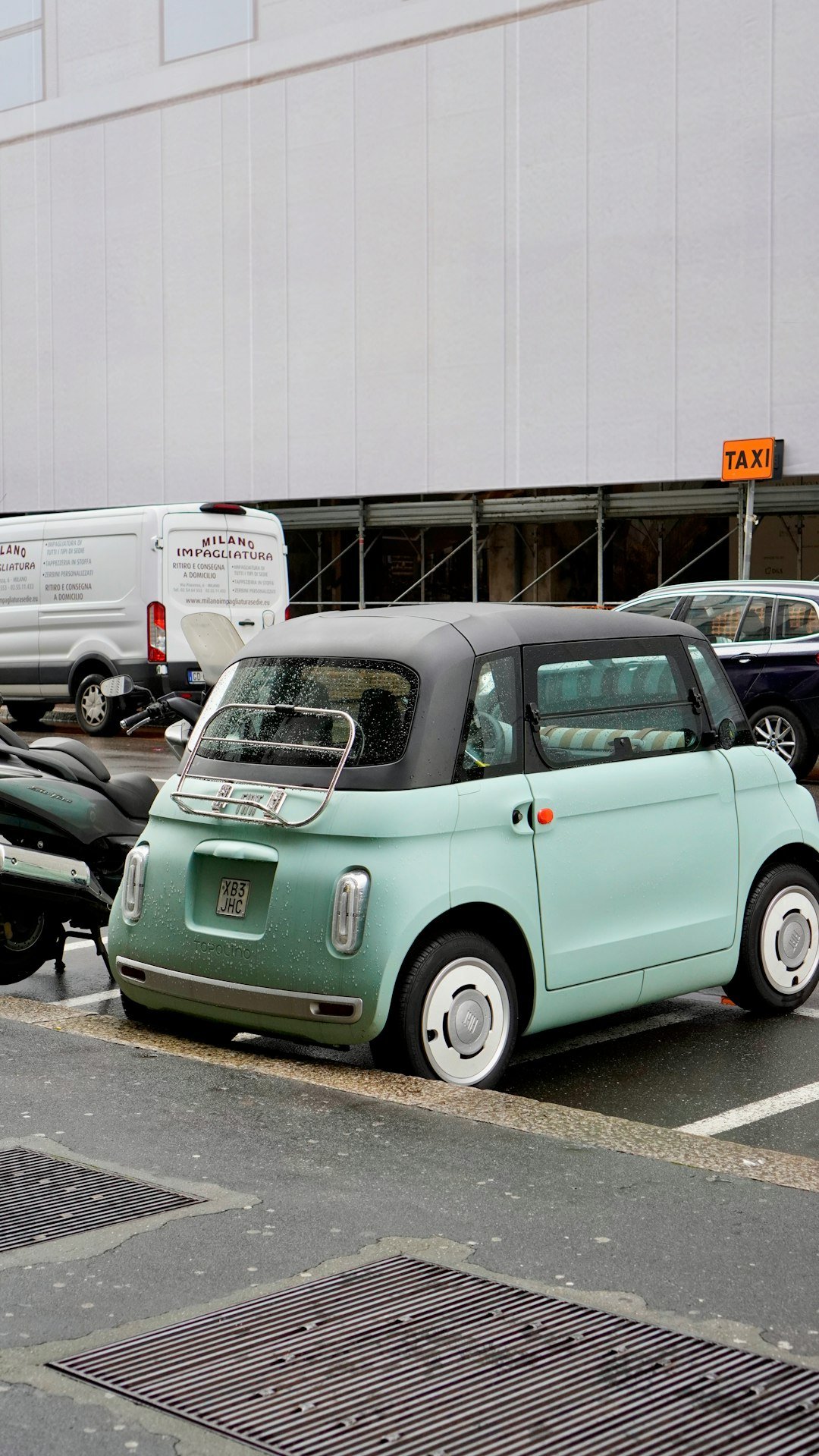A light green convertible car parked outdoors.