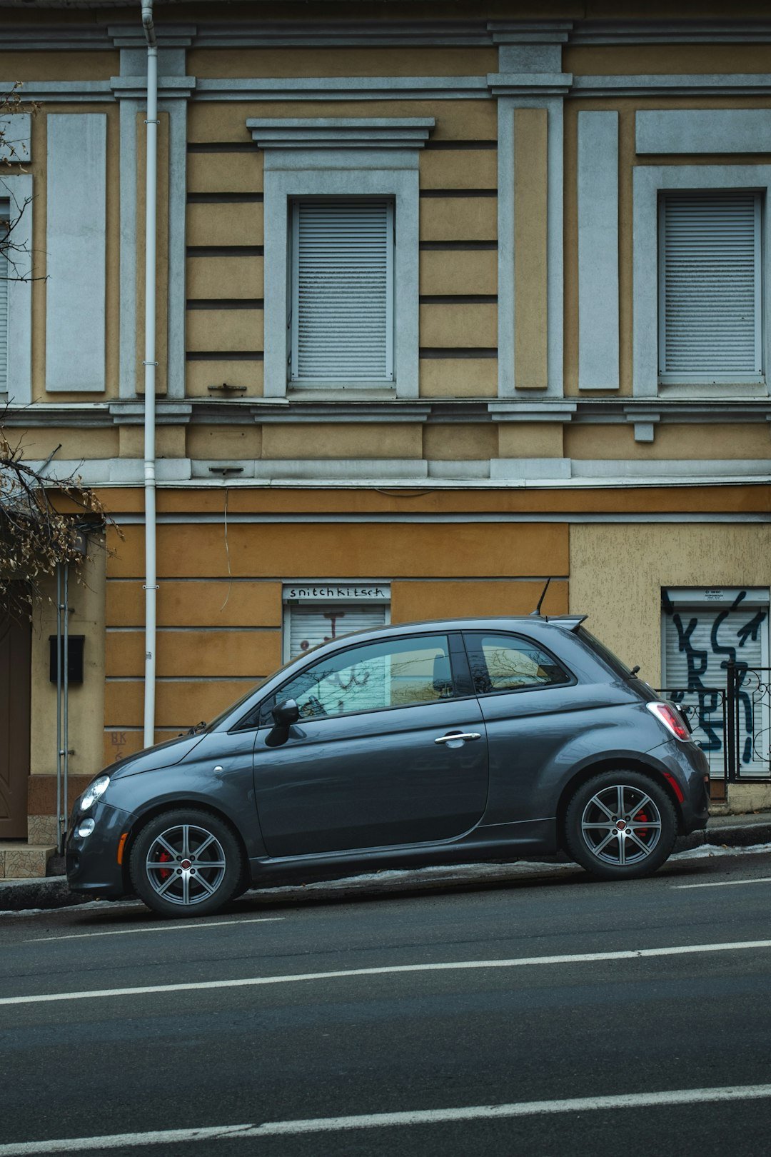 A gray car parked on a city street.