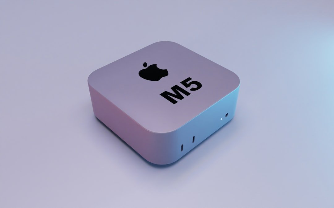 A compact apple m5 computer on a gradient background.