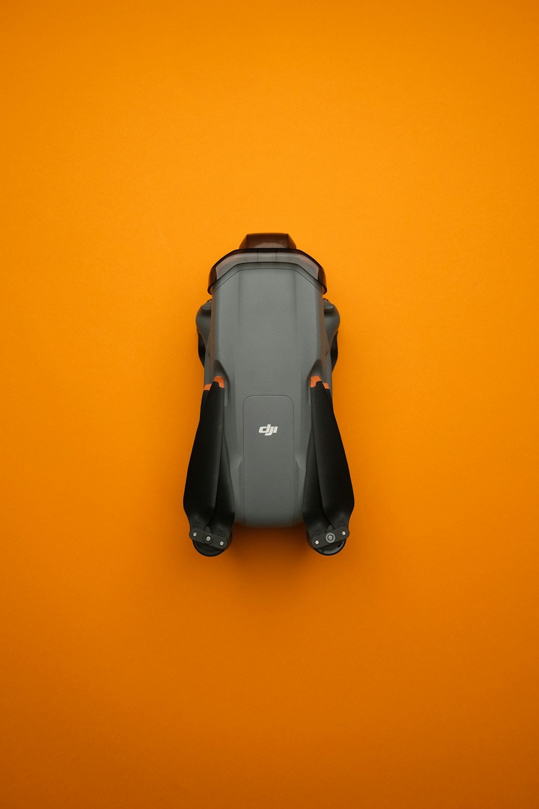 A small grey car on an orange background