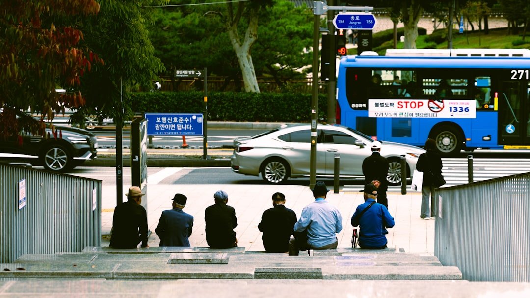 People sitting on stairs with city street in background