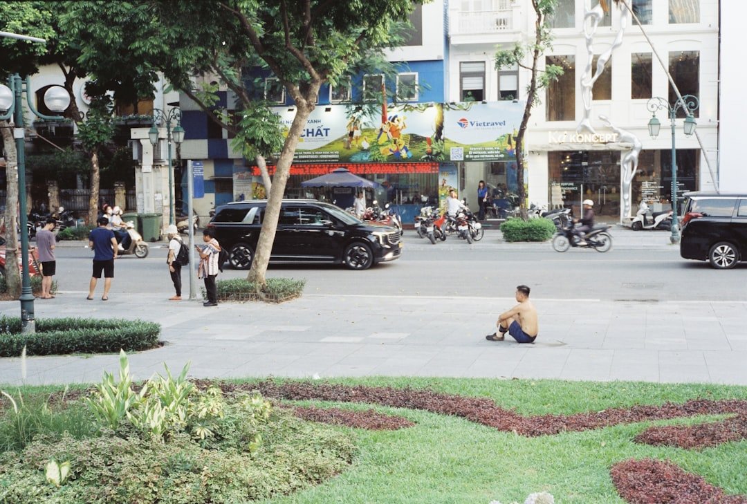 Man sitting on pavement beside urban street scene