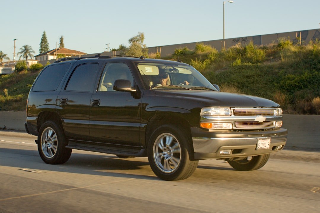 Black chevrolet suburban driving on a sunny highway