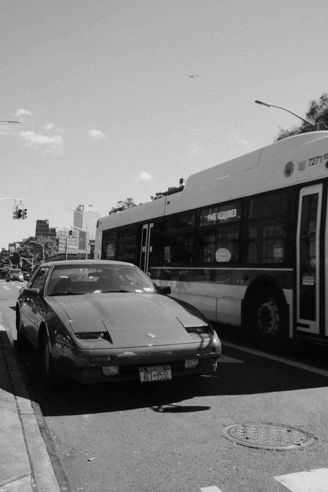 A vintage car parked next to a city bus.