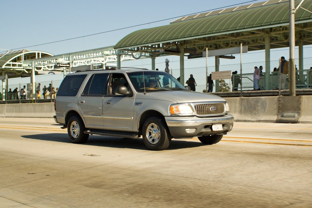 Silver suv driving on a sunny day.