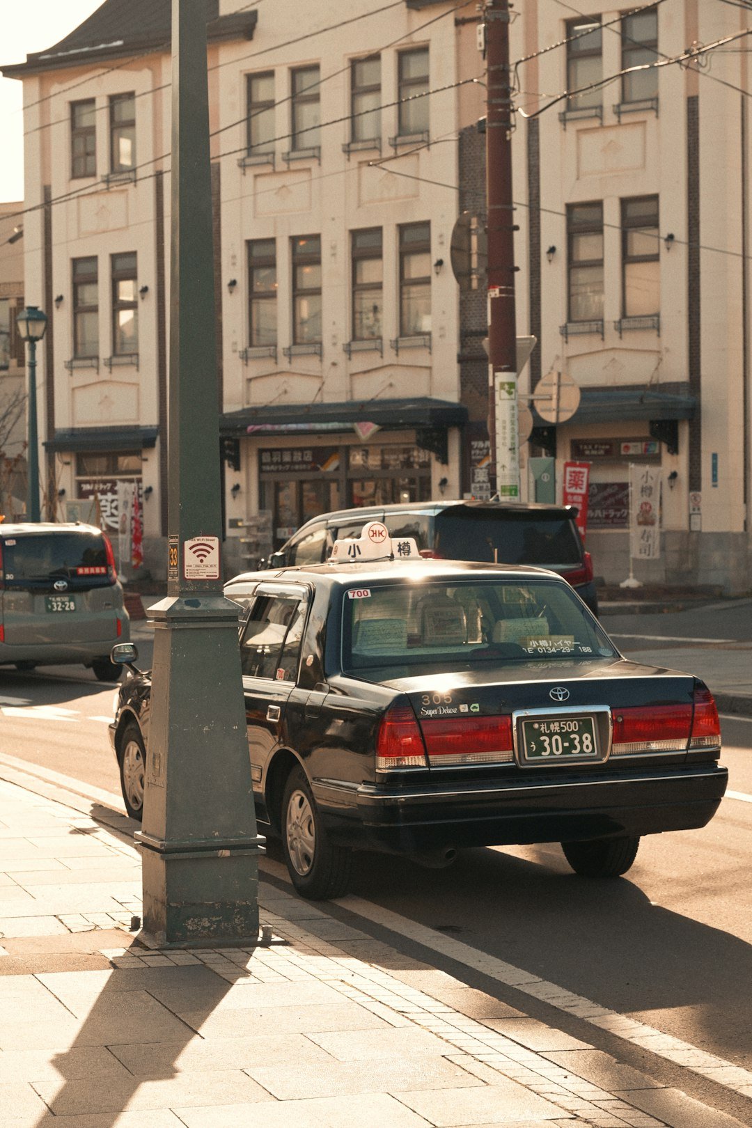 A dark taxi parked on a city street.