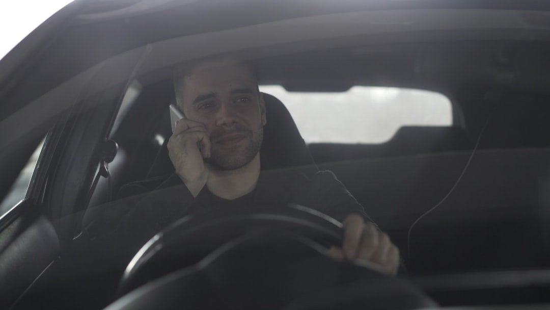 Man talking on phone while driving a car.