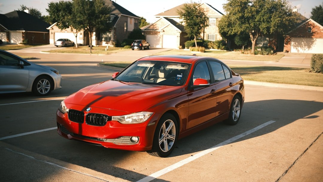 Red sedan parked in a suburban driveway.