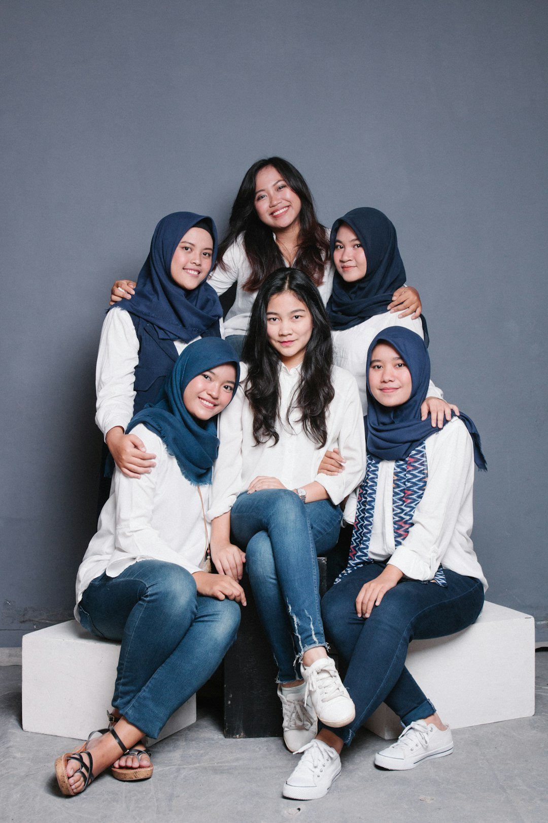 3 women sitting on white couch