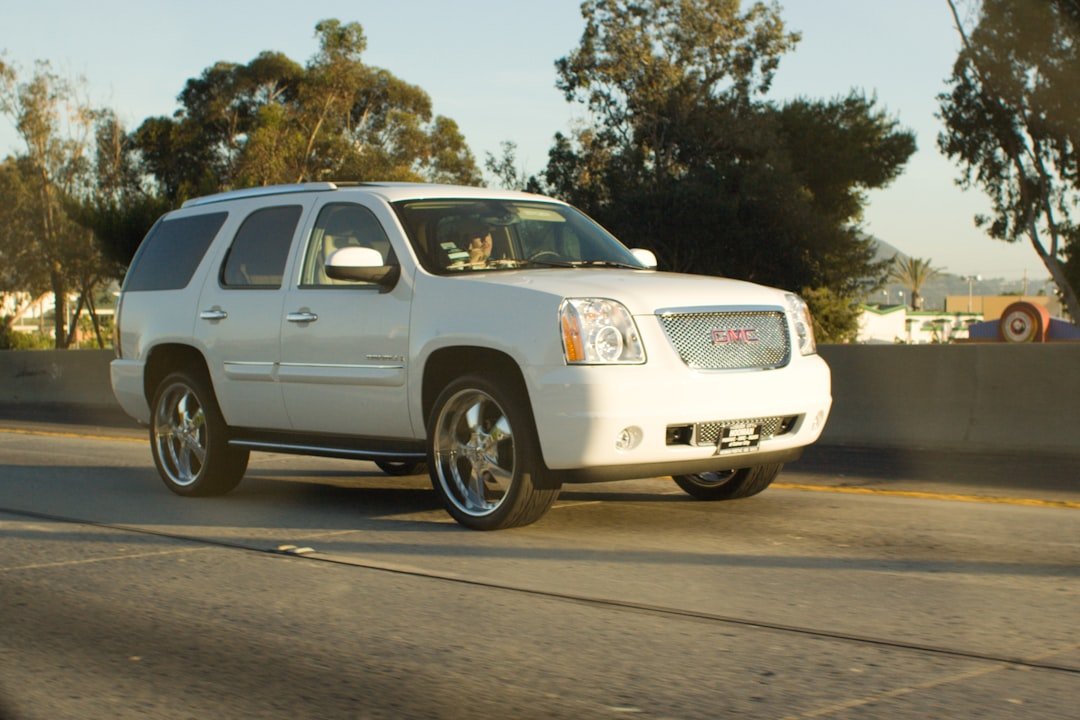 White gmc suv driving on a sunny highway.