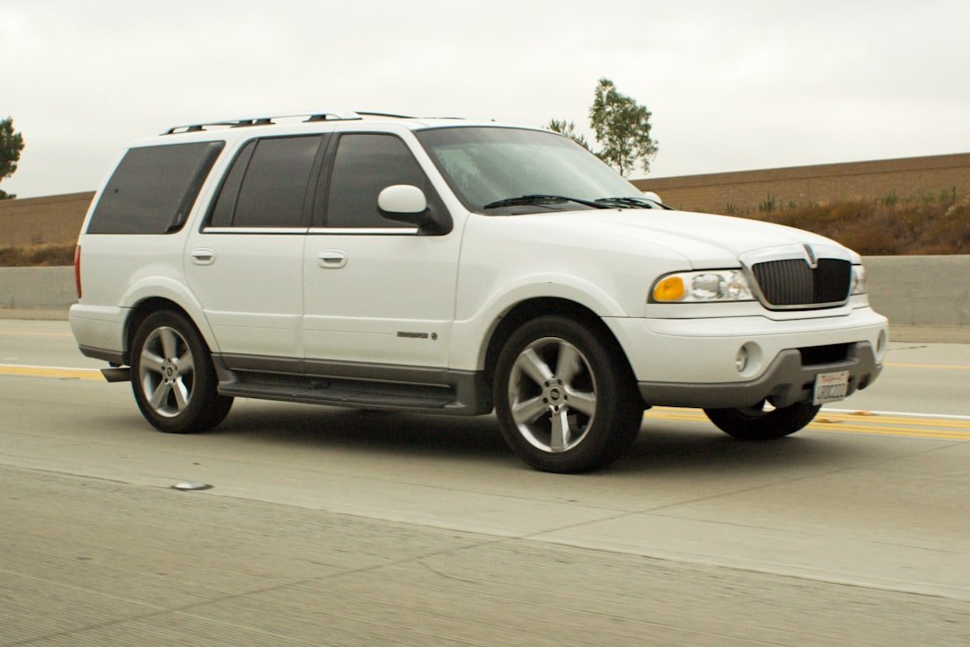 White lincoln navigator driving on a highway.