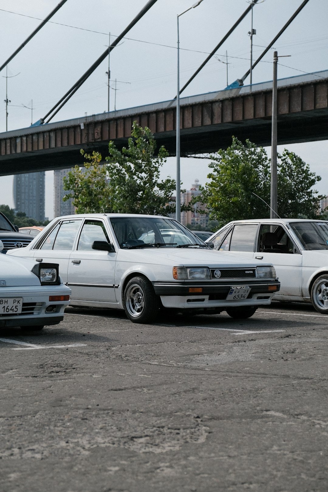 a group of cars parked under a bridge