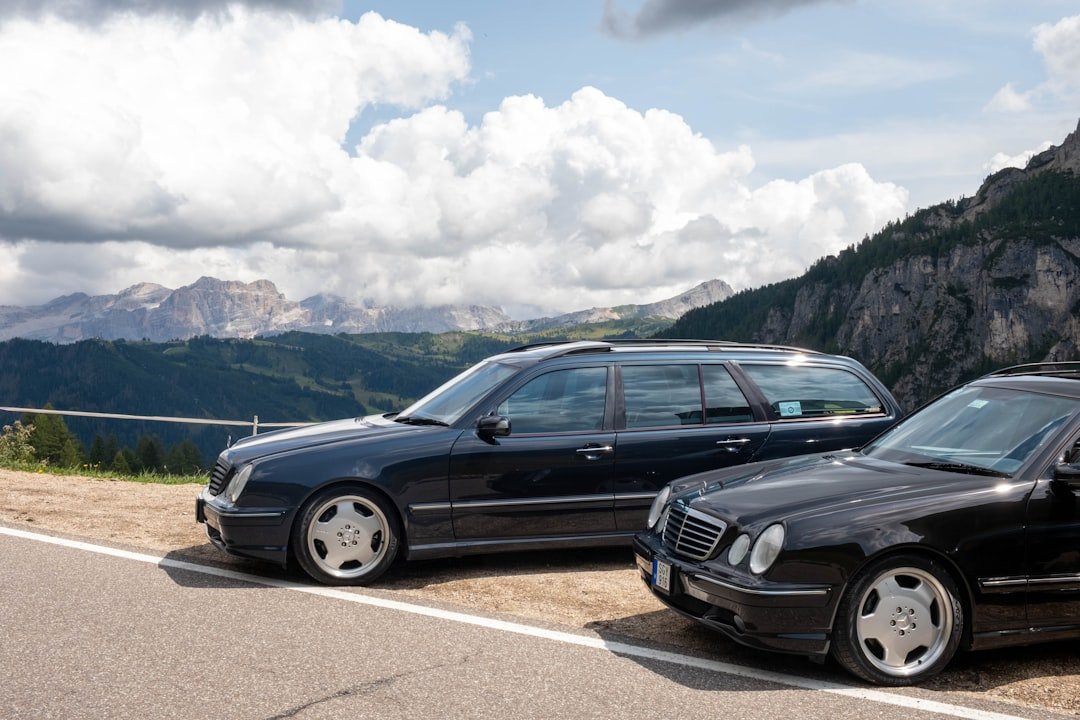 Two dark cars parked on a mountain road.