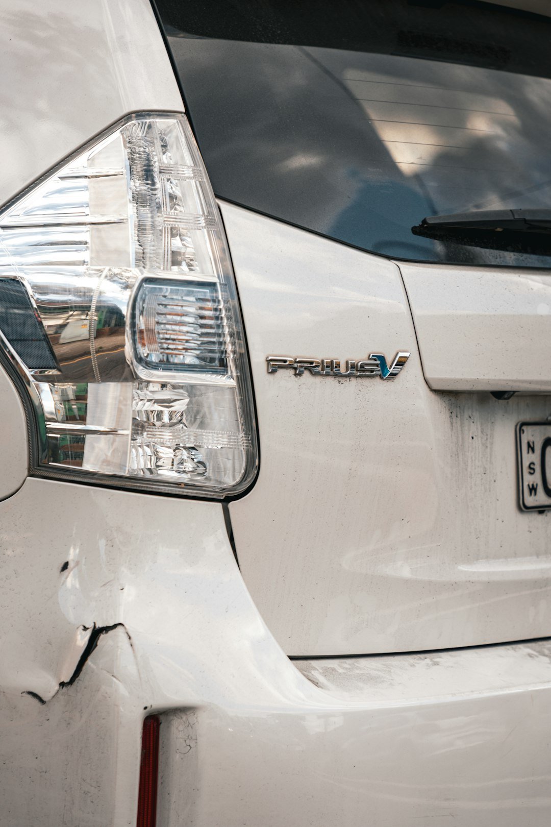 Damaged toyota prius' rear with a dent.