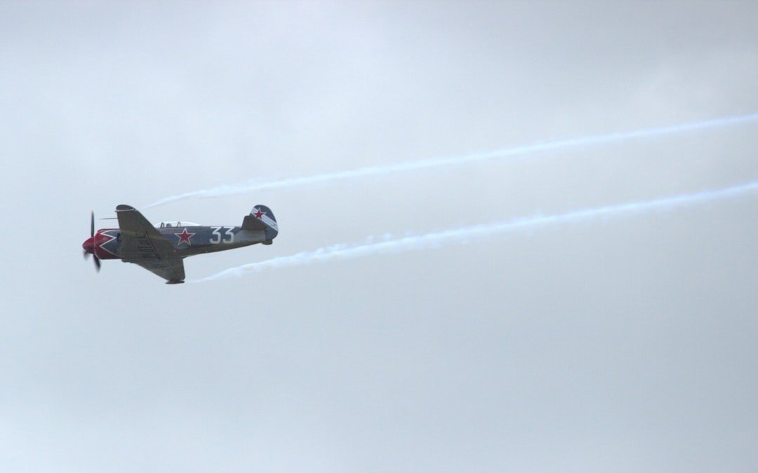 Vintage airplane flies in the cloudy sky.