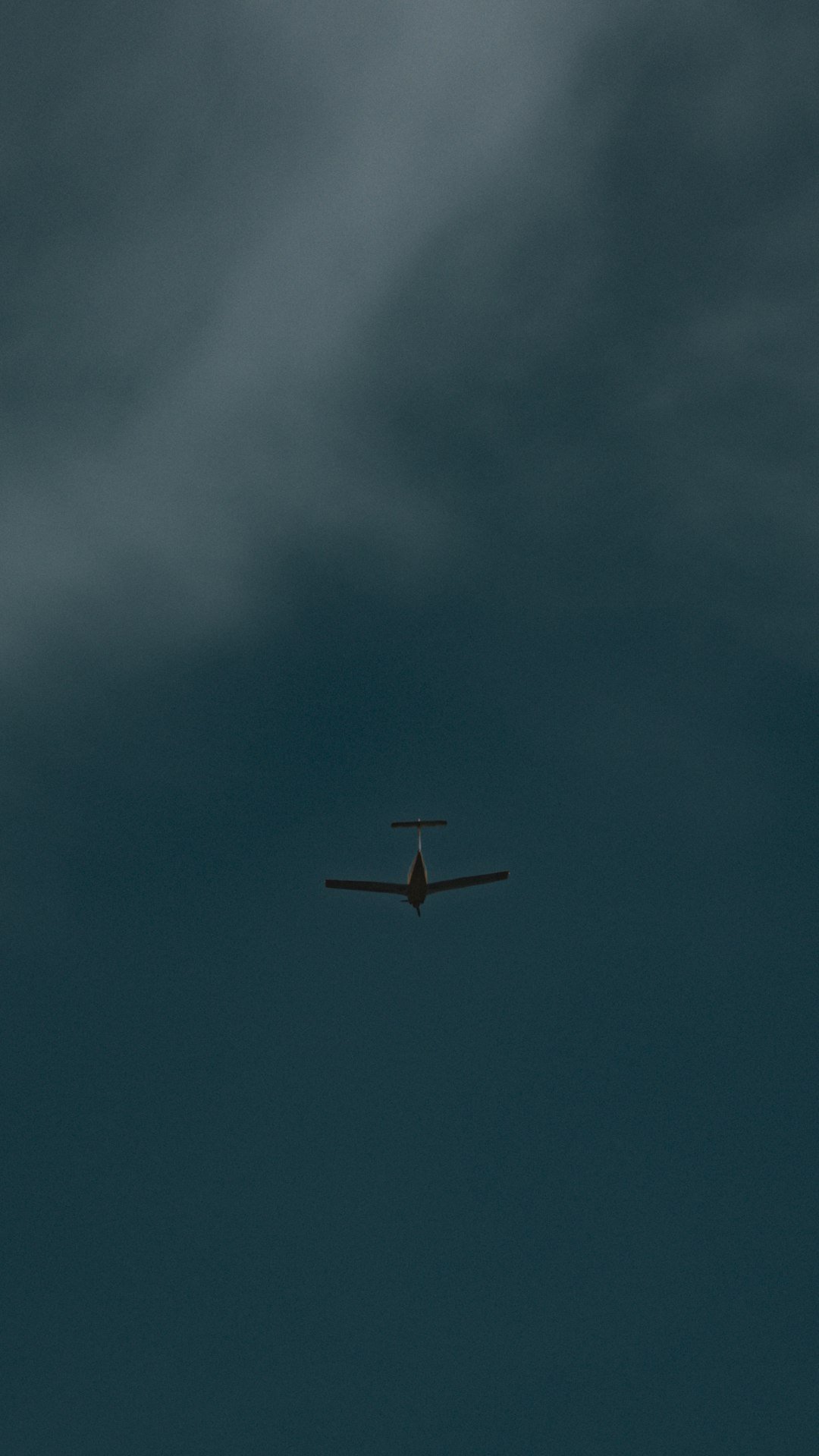 An airplane soars through the dark sky.