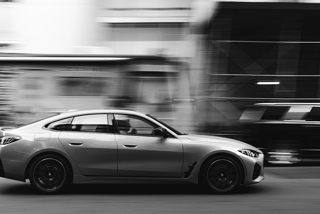 Silver car driving fast on city street