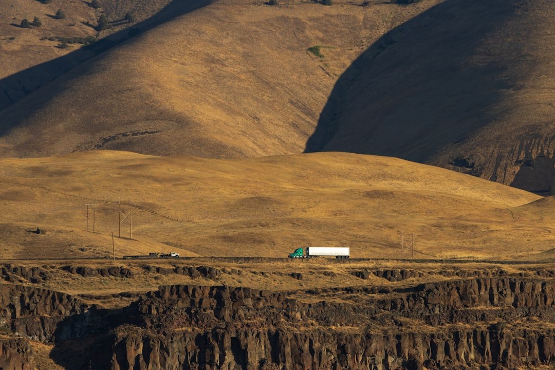 Truck driving on a road through dry hills