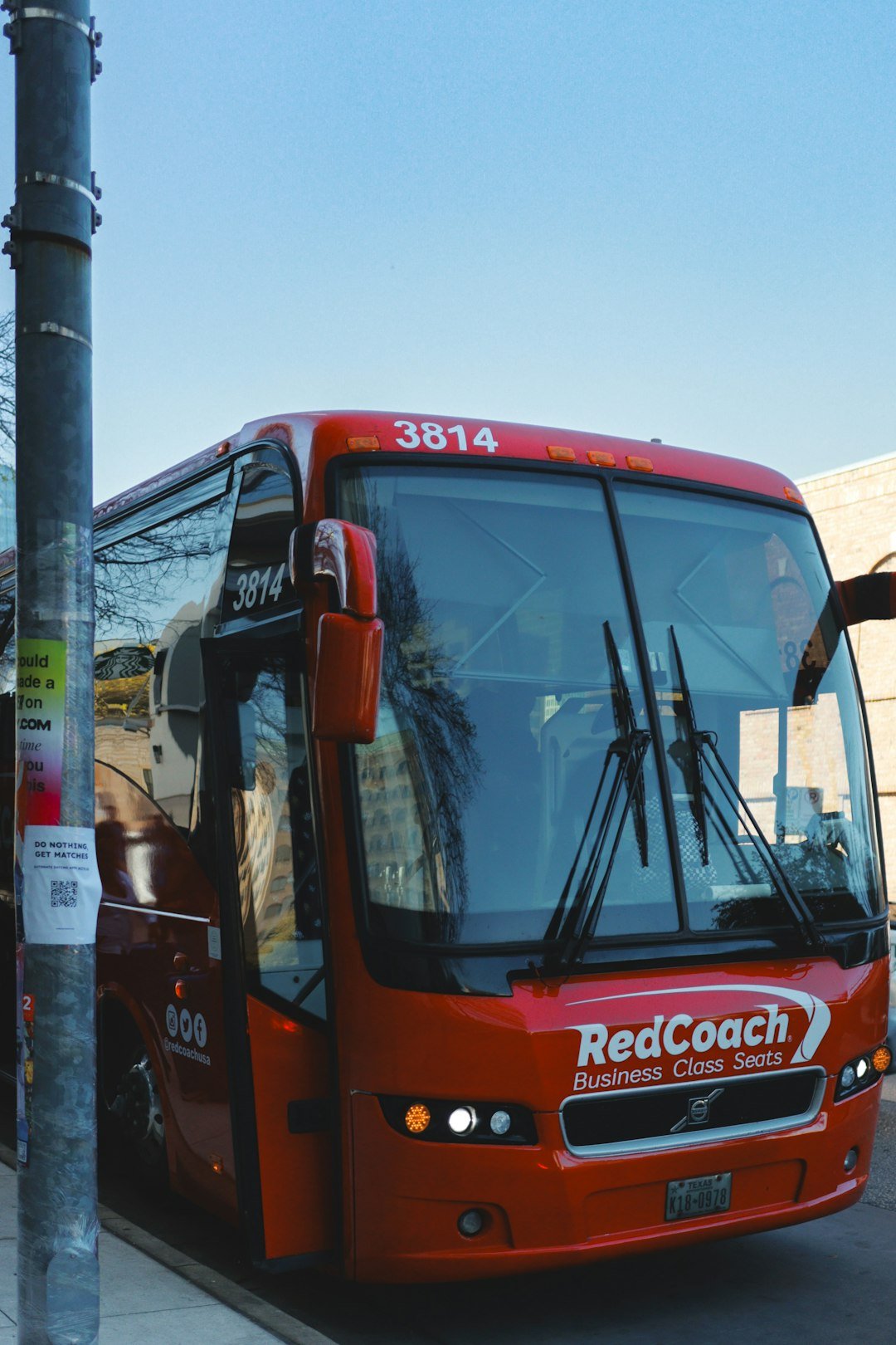 A red redcoach bus parked on the street.